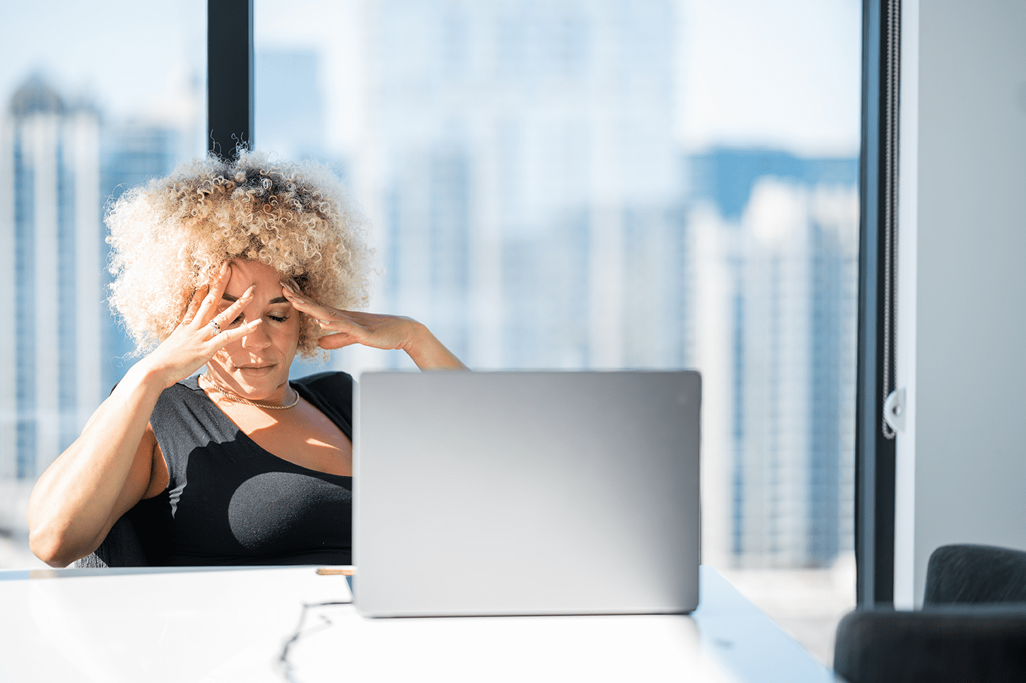 Woman stressed out reading emails on computer.
